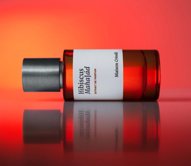 Flakon von Maison Crivelli Hibiscus Mahajád auf rotem Hintergrund, elegantes Parfum mit floralem Charakter.