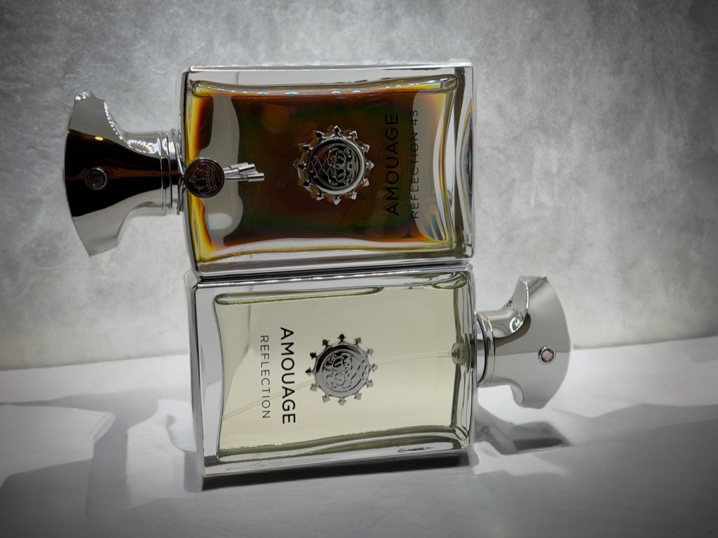 Amouage Reflection Man und Amouage Reflection 45 stehen gemeinsam auf einem hellen Hintergrund. Die beiden Flakons verdeutlichen den Kontrast zwischen der frischen Eleganz von Reflection Man und der warmen, intensiven Tiefe von Reflection 45.