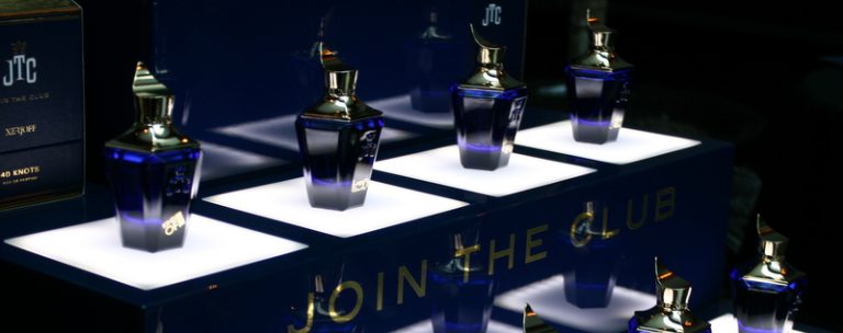 Alte Parfum-Batches aus der Xerjoff Join the Club Kollektion, mehrere originale Flakons auf beleuchteten Podesten präsentiert