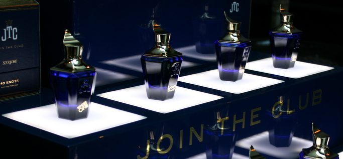 Alte Parfum-Batches aus der Xerjoff Join the Club Kollektion, mehrere originale Flakons auf beleuchteten Podesten präsentiert