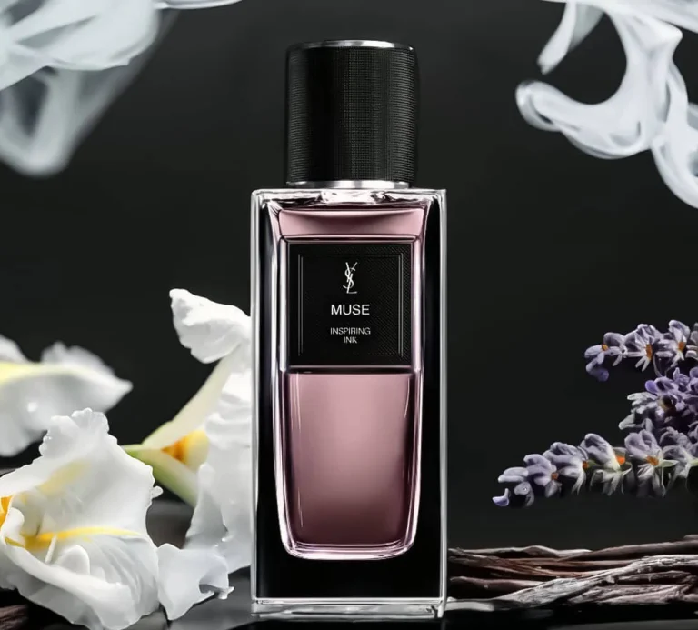 Flakon von Yves Saint Laurent Muse – Inspiring Ink vor weißer Iris, Lavendelzweigen, Vanilleschoten und zartem Rauch auf dunklem Hintergrund.